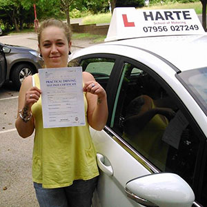 Happy young woman holding pass certificate at Chesterfield test centre.